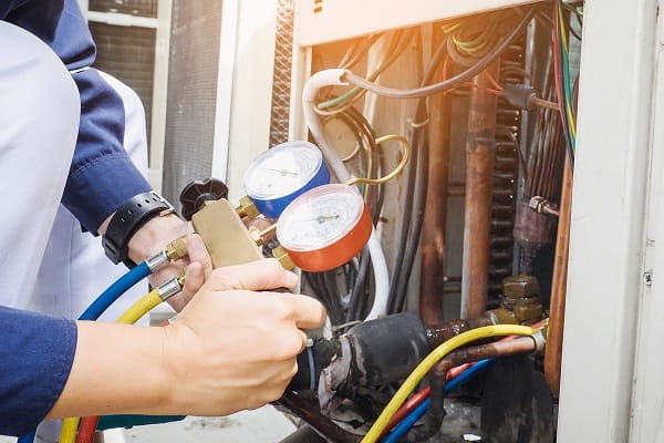 AC repair technician servicing an outdoor condenser